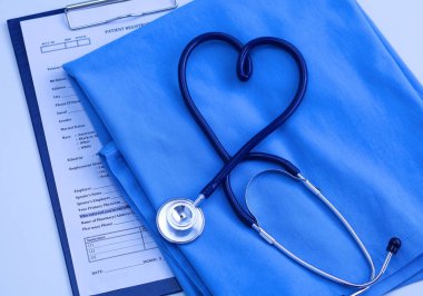 Sağlık stetoskop yalan hasta tıbbi geçmiş listesi ve mavi doktor Tekdüzen portre üzerinde kalp şeklinde bükülmüş. Tıbbi yardım veya sigorta kavramı. Kardiyoloji Bakımı, sağlık, koruma ve korunma
