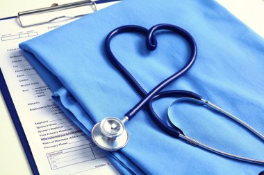 Sağlık stetoskop yalan hasta tıbbi geçmiş listesi ve mavi doktor Tekdüzen portre üzerinde kalp şeklinde bükülmüş. Tıbbi yardım veya sigorta kavramı. Kardiyoloji Bakımı, sağlık, koruma ve korunma