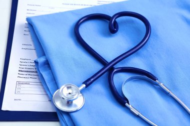 Sağlık stetoskop yalan hasta tıbbi geçmiş listesi ve mavi doktor Tekdüzen portre üzerinde kalp şeklinde bükülmüş. Tıbbi yardım veya sigorta kavramı. Kardiyoloji Bakımı, sağlık, koruma ve korunma