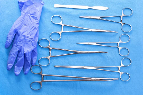 Instruments et outils chirurgicaux, y compris scalpels, pinces et pinces à épiler, disposés sur une table pour une intervention chirurgicale — Photo