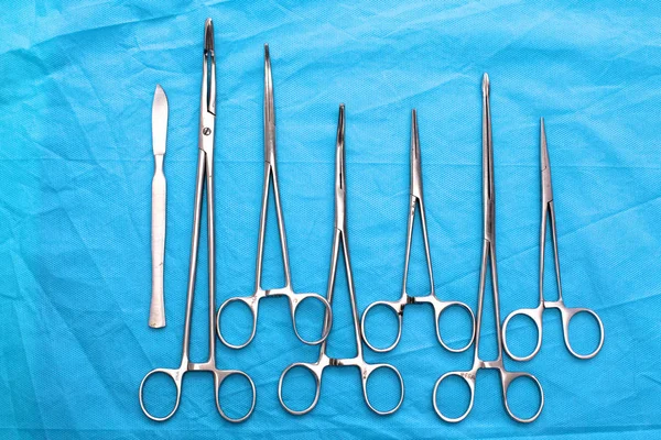 Instrumentos y herramientas quirúrgicas, incluidos bisturíes, pinzas y pinzas dispuestas en una mesa para una cirugía —  Fotos de Stock