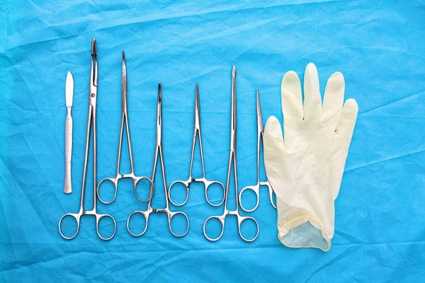 Instrumentos e ferramentas cirúrgicos, incluindo bisturis, pinças e pinças dispostos em uma mesa para uma cirurgia — Fotografia de Stock