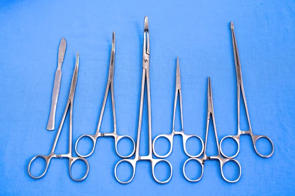 Chirurgické nástroje a nástroje včetně skalpelů, kleští a pinzet umístěných na stole pro chirurgii — Stock fotografie