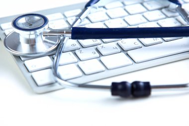 Beyaz ahşap bir masa üstünde a laptop yanında sağlık stetoskop