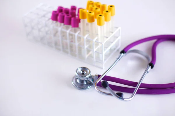 Stéthoscope près des tubes médicaux sur fond blanc — Photo