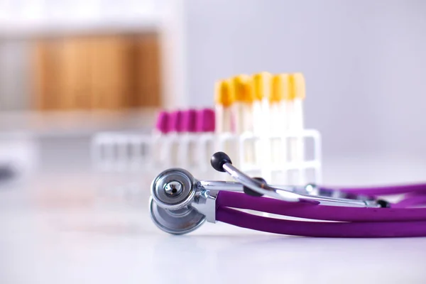 Stetoskop nära medicinsk rören på vit bakgrund — Stockfoto