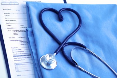 Sağlık stetoskop yalan hasta tıbbi geçmiş listesi ve mavi doktor Tekdüzen portre üzerinde kalp şeklinde bükülmüş. Tıbbi yardım veya sigorta kavramı. Kardiyoloji Bakımı, sağlık, koruma ve korunma