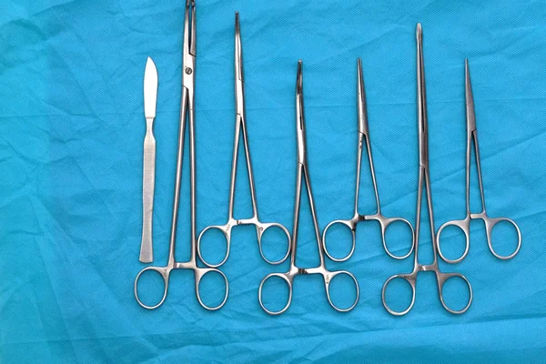 Instrumentos y herramientas quirúrgicas, incluidos bisturíes, pinzas y pinzas dispuestas en una mesa para una cirugía —  Fotos de Stock