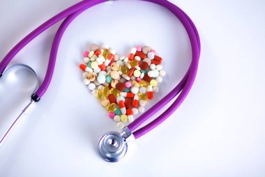 Steteskop ve yanında yalan kalp ile masaya yaymak hap yakın çekim