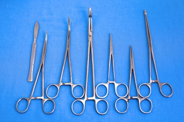 Ameliyat için masaya yerleştirilmiş neşter, pens ve cımbız gibi cerrahi aletler ve aletler.