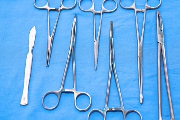 surgical instruments and tools including scalpels, forceps and tweezers arranged on a table for a surgery