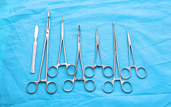 Surgical instruments and tools including scalpels, forceps and tweezers arranged on a table for a surgery — Stock Photo, Image