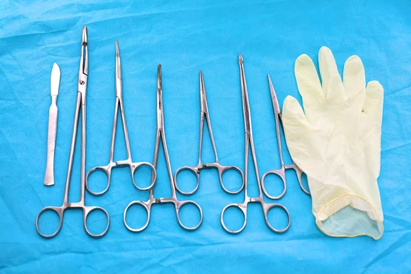 Strumenti e strumenti chirurgici, compresi bisturi, pinzette e pinzette disposti su un tavolo per un intervento chirurgico — Foto Stock
