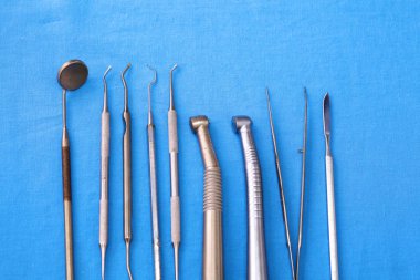 Ameliyat için masaya yerleştirilmiş neşter, pens ve cımbız gibi cerrahi aletler ve aletler.