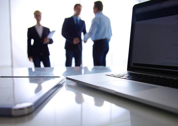 Сосредоточься на ноутбуке. Размытые люди на заднем плане
