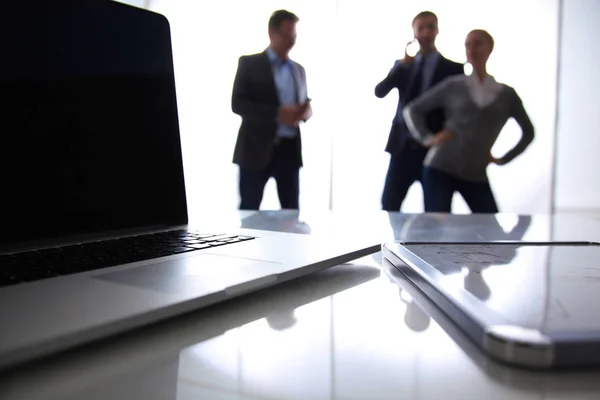 Focus op laptop op de tafel. Wazig mensen op achtergrond — Stockfoto