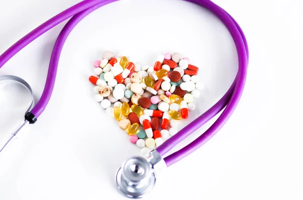 Tabletta elosztva a táblázat sztetoszkóp és a szív mellett közelről — Stock Fotó