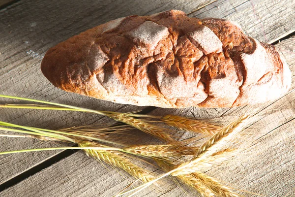 Freshly baked traditional bread on wooden table — Stock Photo, Image