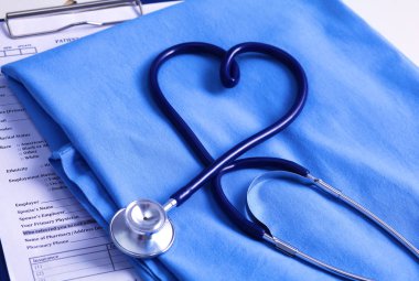 Sağlık stetoskop yalan hasta tıbbi geçmiş listesi ve mavi doktor Tekdüzen portre üzerinde kalp şeklinde bükülmüş
