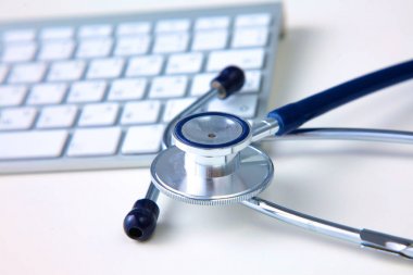 Beyaz ahşap bir masa üstünde a laptop yanında sağlık stetoskop