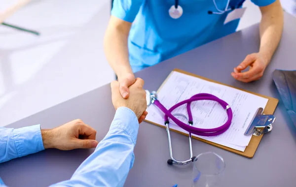 Uno stetoscopio medico vicino a un computer portatile su un tavolo di legno, su bianco — Foto Stock