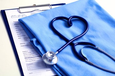 Sağlık stetoskop yalan hasta tıbbi geçmiş listesi ve mavi doktor Tekdüzen portre üzerinde kalp şeklinde bükülmüş