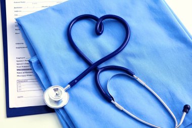 Sağlık stetoskop yalan hasta tıbbi geçmiş listesi ve mavi doktor Tekdüzen portre üzerinde kalp şeklinde bükülmüş