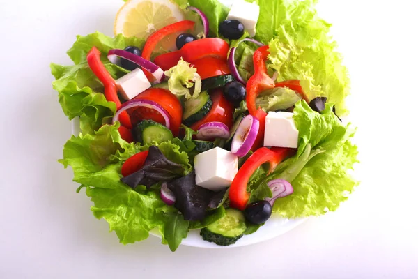 Salát z čerstvé zeleniny a bylin na stole v desce — Stock fotografie