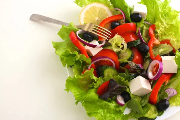 Sallad på färska grönsaker och örter på bordet i plattan — Stockfoto