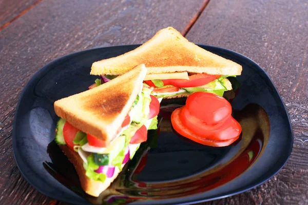 Sanduíche vegetariano com tomate em uma placa preta — Fotografia de Stock