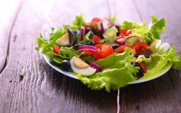 Verdure fresche su fondo legno e sfocato — Foto Stock