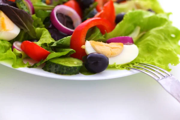 Sallad på färska grönsaker och örter på bordet i plattan — Stockfoto