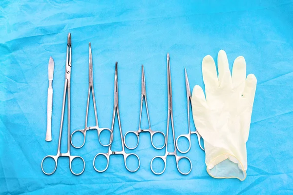 surgical instruments and tools including scalpels, forceps and tweezers arranged on a table for a surgery