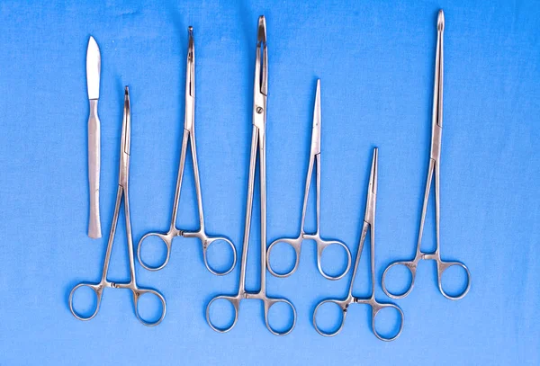 Ameliyat için masaya yerleştirilmiş neşter, pens ve cımbız gibi cerrahi aletler ve aletler.