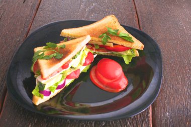 Pancar kökü, domates, mısır salatası ve ahşap arkaplanda roka yapılmış vejetaryen burger.