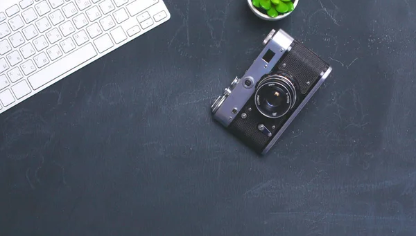 Computer keyboard, cactus and camera lie on table — Stock Photo, Image