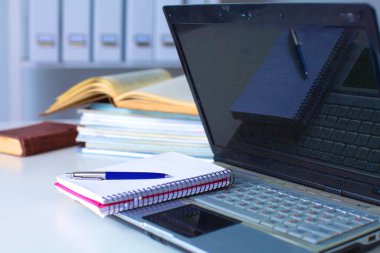 Bir iş Danışma iç ile bir dizüstü bilgisayar, bir fincan kahve ve beyaz perde güneşli bir görünümünü kapat