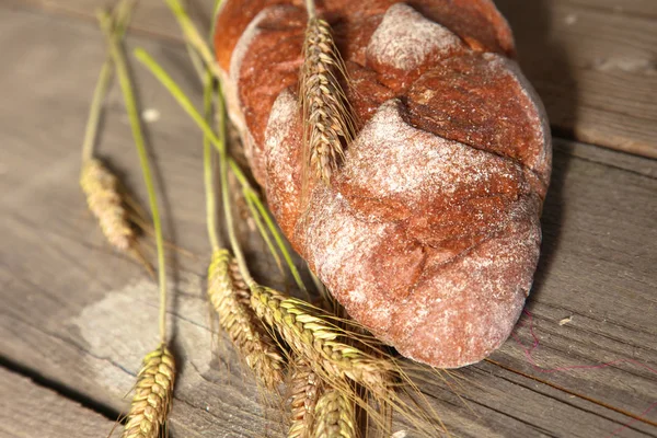 Freshly baked traditional bread on wooden table — Stock Photo, Image