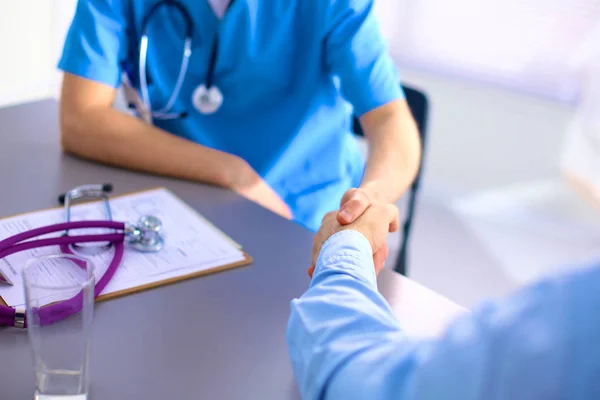 Médica atraente apertando as mãos de um paciente em seu escritório — Fotografia de Stock