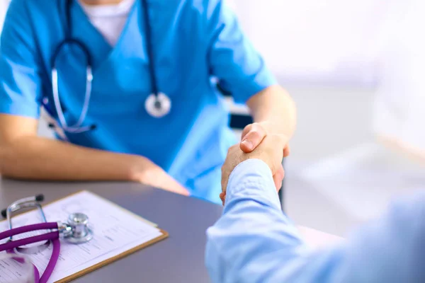 Attraente medico femminile che stringe una mano ai pazienti nel suo ufficio — Foto Stock