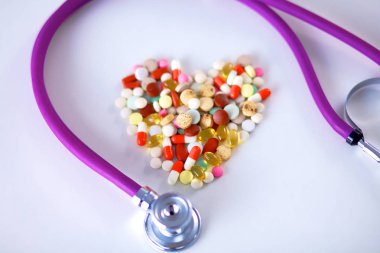 Stetoskop ve beyaz arka planda izole edilmiş bazı haplar.