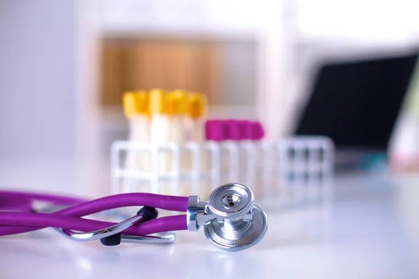 Stéthoscope et ordinateur sur un bureau au bureau — Photo