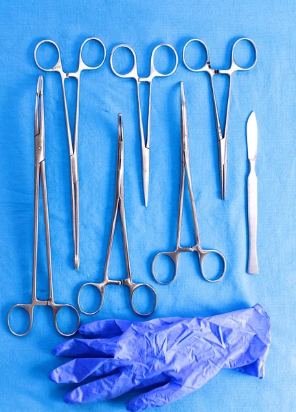Хирургические инструменты и инструменты, включая скальпели, щипцы и пинцет, расположенные на столе для операции — стоковое фото