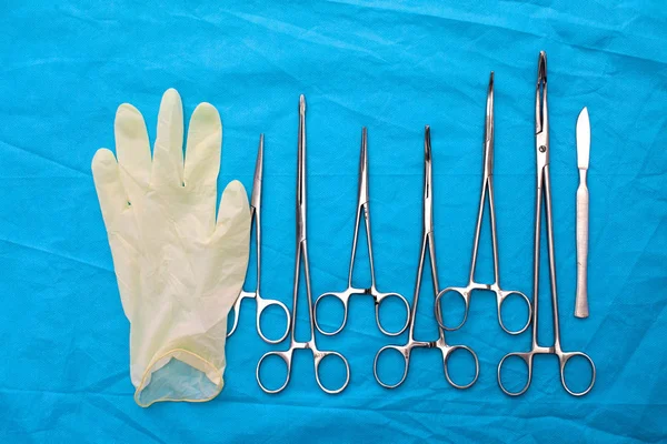 Surgical instruments and tools including scalpels, forceps and tweezers arranged on a table for a surgery — Stock Photo, Image