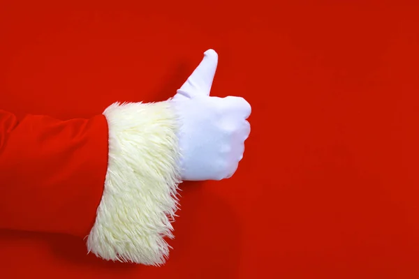 Santa Claus hand presenting your christmas text or product over red background with copy space — Stock Photo, Image