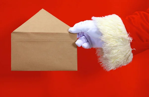 Санта-Клаус вручает свой текст или продукт на красном фоне с пространством для копирования — стоковое фото