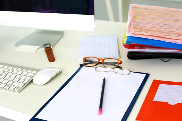 Table de bureau avec bloc-notes vierge et ordinateur portable — Photo