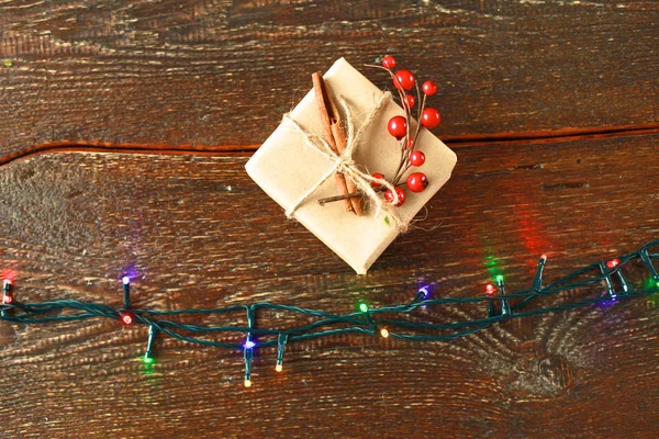 Cadeau de Noël ou boîte cadeau enveloppé dans du papier kraft avec décoration sur fond de bois rustique — Photo