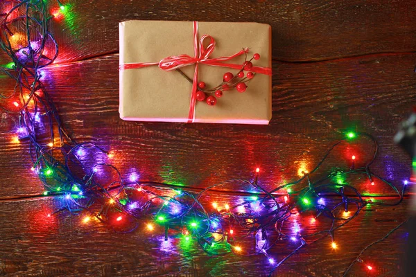 Cadeau de Noël ou boîte cadeau enveloppé dans du papier kraft avec décoration sur fond de bois rustique — Photo