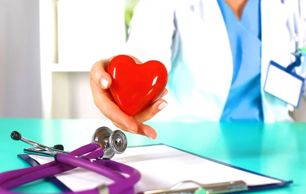 Kadın doktor bir stetoskop ile bir kalp tutar — Stok fotoğraf